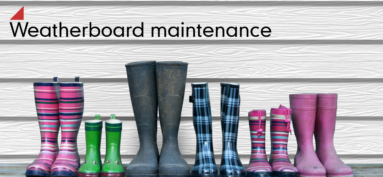 Image with boots in front of white planks with text near the left corner. The text reads: "Weatherboard maintenance"