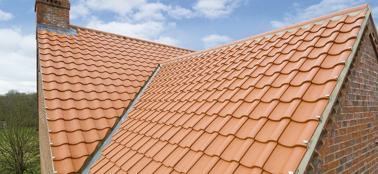Lincoln clay interlocking tile in natural red showing chimney flashing detail